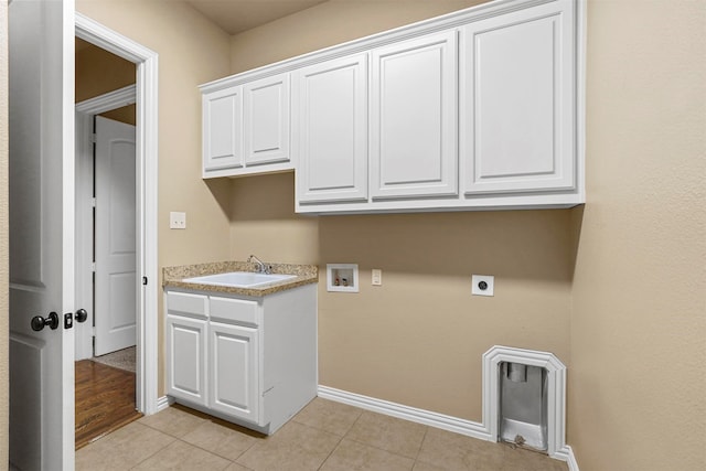 laundry area with electric dryer hookup, cabinets, sink, washer hookup, and light tile patterned floors