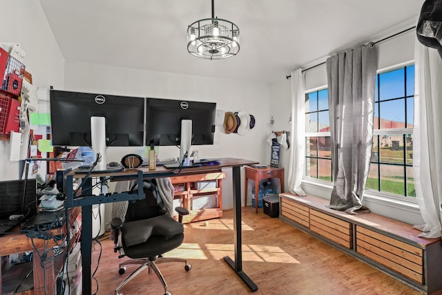 home office with an inviting chandelier and light wood-type flooring