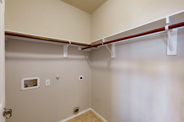 washroom featuring hookup for a gas dryer, light tile patterned floors, washer hookup, and hookup for an electric dryer