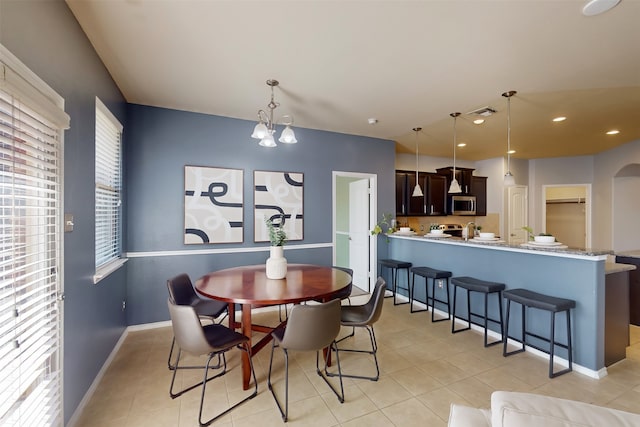 dining area with a notable chandelier and light tile patterned flooring