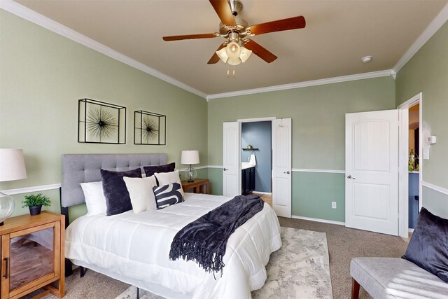 carpeted bedroom featuring ceiling fan, ornamental molding, and ensuite bath