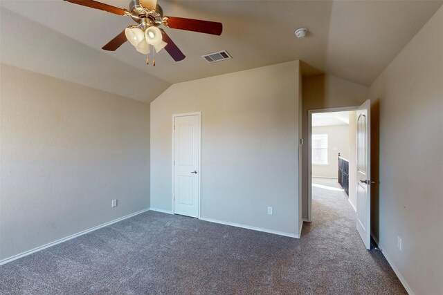 unfurnished bedroom with dark colored carpet, ceiling fan, and lofted ceiling