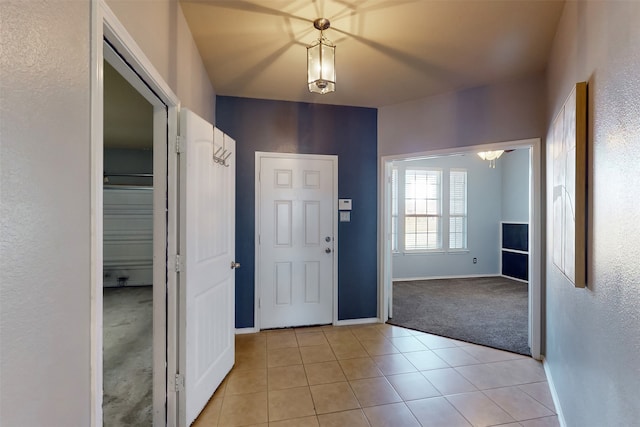 foyer entrance with light tile patterned floors and an inviting chandelier