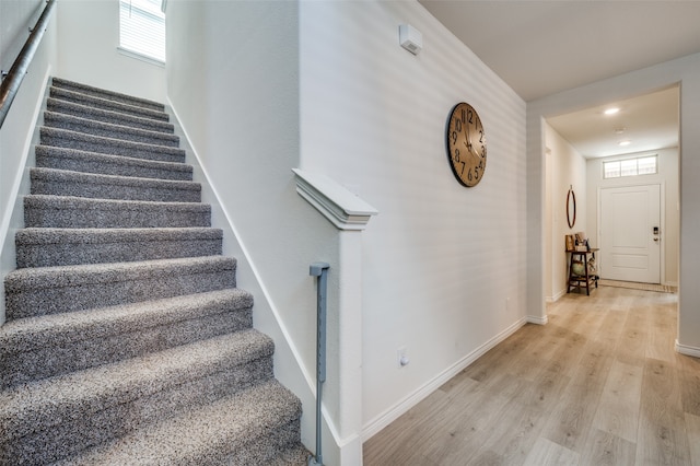 staircase featuring hardwood / wood-style floors and a healthy amount of sunlight