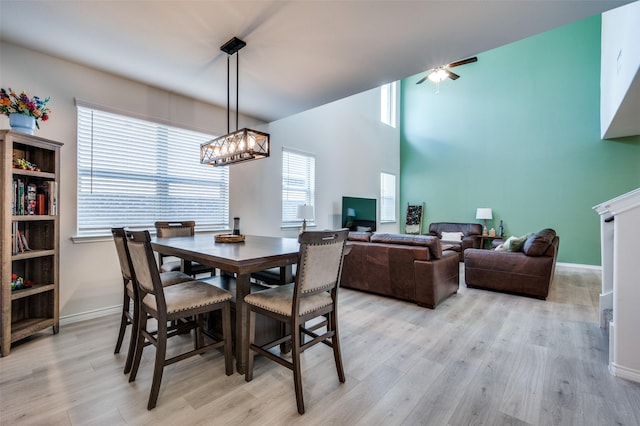 dining room featuring a high ceiling, an inviting chandelier, and light hardwood / wood-style flooring