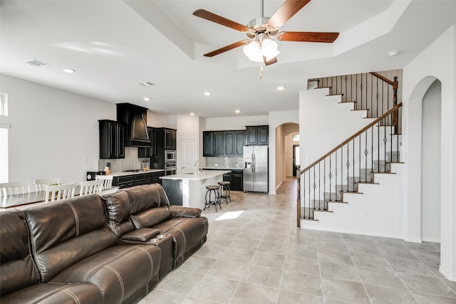 living room with ceiling fan, light tile patterned floors, and sink