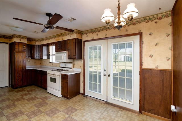 kitchen with french doors, dark brown cabinets, ceiling fan with notable chandelier, white appliances, and pendant lighting