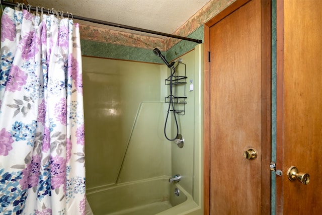 bathroom with shower / tub combo and a textured ceiling