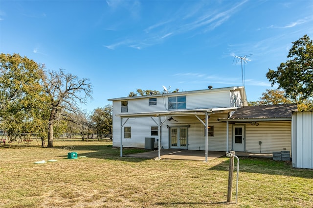 rear view of property featuring french doors, a yard, central AC unit, and a patio area