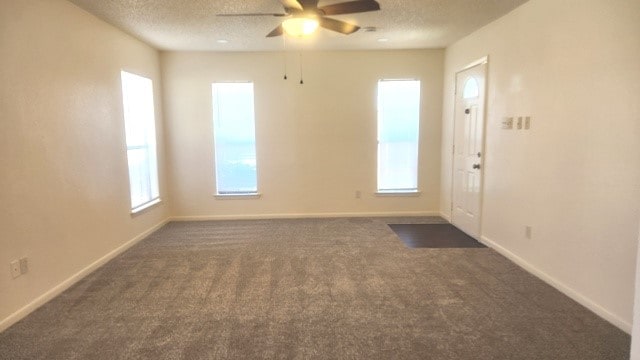 carpeted spare room featuring ceiling fan and a textured ceiling