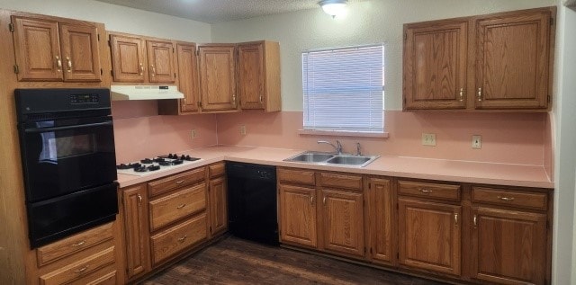 kitchen featuring a textured ceiling, sink, dark hardwood / wood-style floors, and black appliances