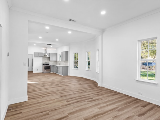 unfurnished living room with crown molding and light hardwood / wood-style floors