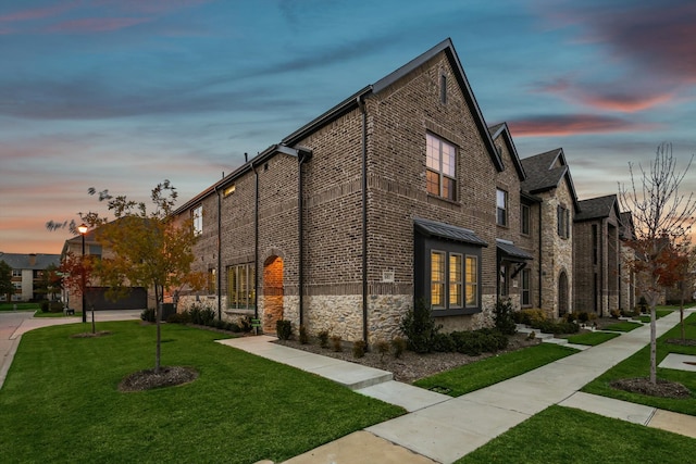 property exterior at dusk featuring a yard