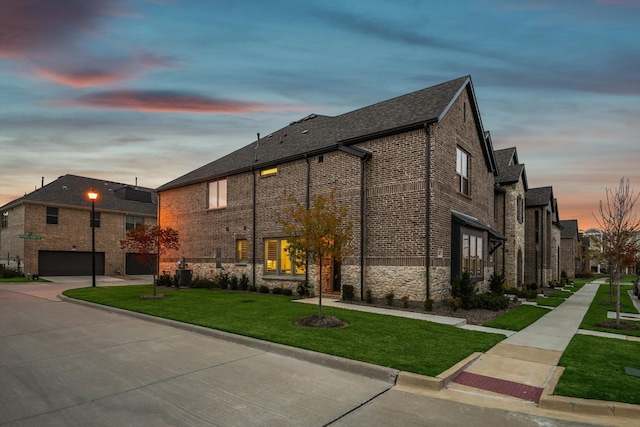 view of front of house with cooling unit, a garage, and a yard