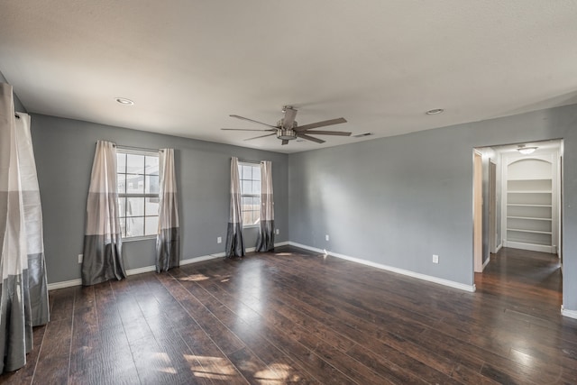 unfurnished room with ceiling fan and dark wood-type flooring