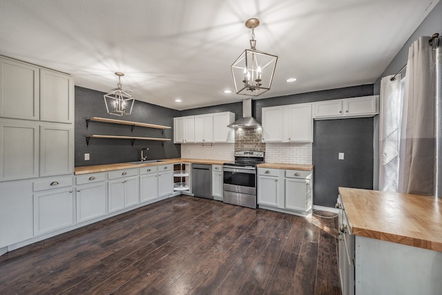 kitchen with butcher block countertops, white cabinets, hanging light fixtures, and appliances with stainless steel finishes