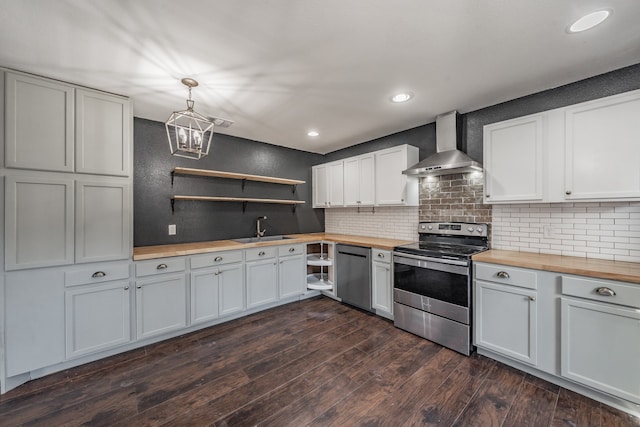 kitchen featuring wooden counters, stainless steel appliances, dark wood-type flooring, wall chimney range hood, and hanging light fixtures