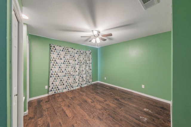 empty room with a textured ceiling, dark hardwood / wood-style floors, and ceiling fan