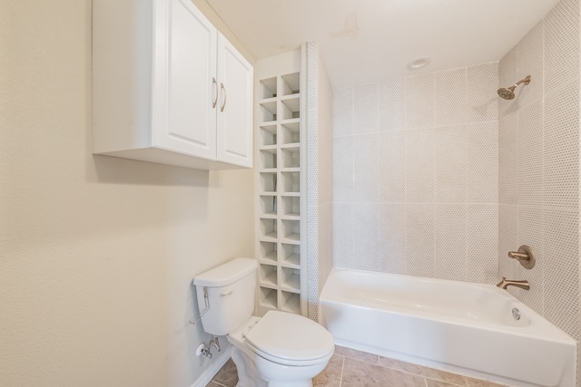 bathroom with tile patterned floors, toilet, and tiled shower / bath