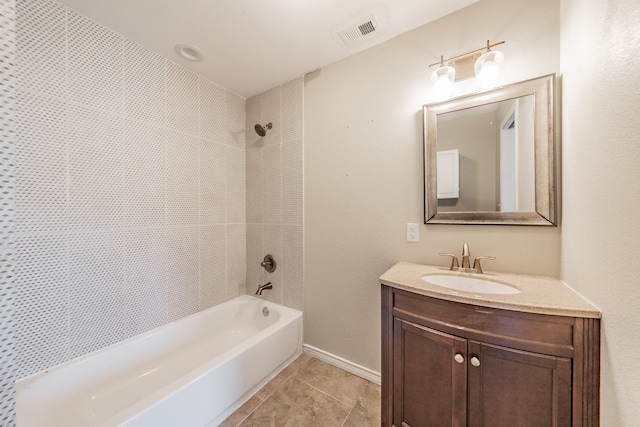 bathroom with tile patterned flooring, vanity, and tiled shower / bath