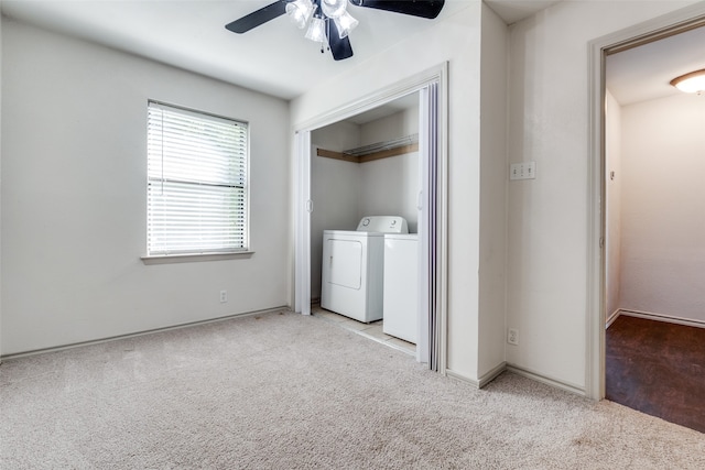 clothes washing area featuring ceiling fan, light colored carpet, and separate washer and dryer