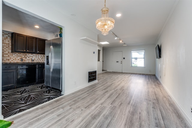 interior space with light wood-type flooring, ornamental molding, and a chandelier