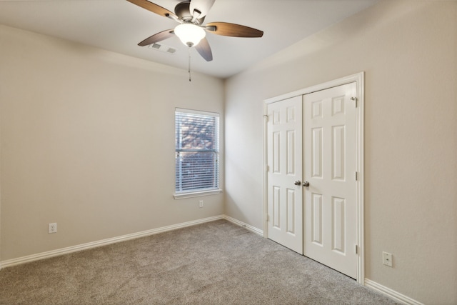 unfurnished bedroom with light carpet, a closet, and ceiling fan