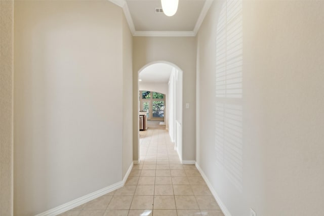 hallway with light tile patterned flooring and ornamental molding