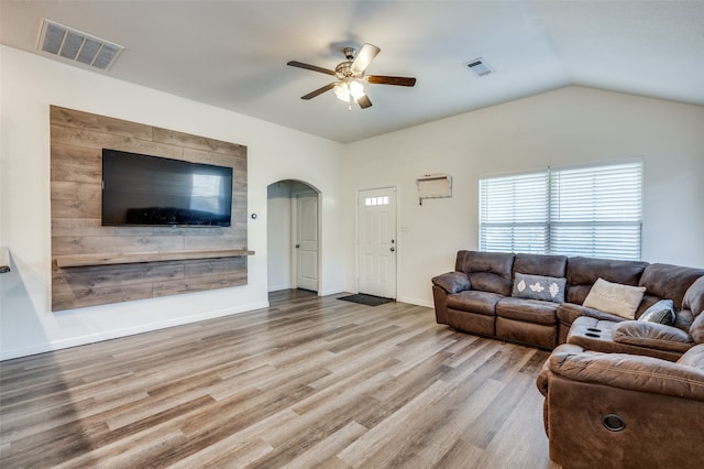 living room with ceiling fan, light hardwood / wood-style floors, and vaulted ceiling