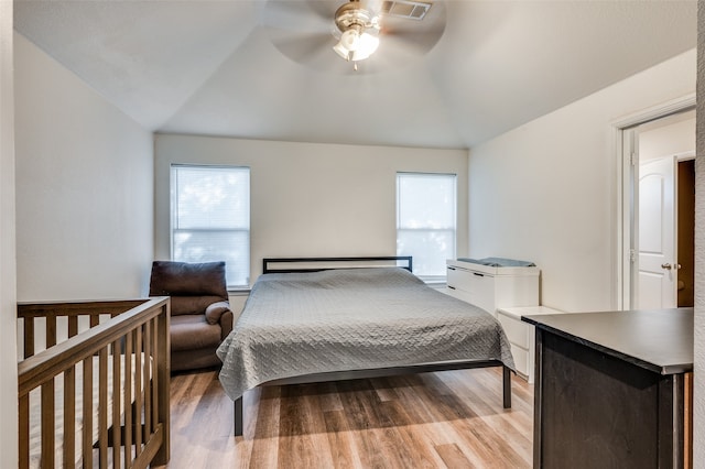 bedroom featuring ceiling fan, light wood-type flooring, lofted ceiling, and multiple windows