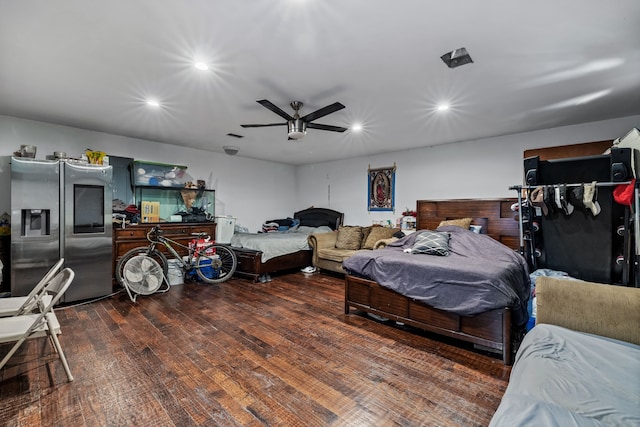 bedroom with stainless steel refrigerator with ice dispenser, ceiling fan, and dark hardwood / wood-style flooring