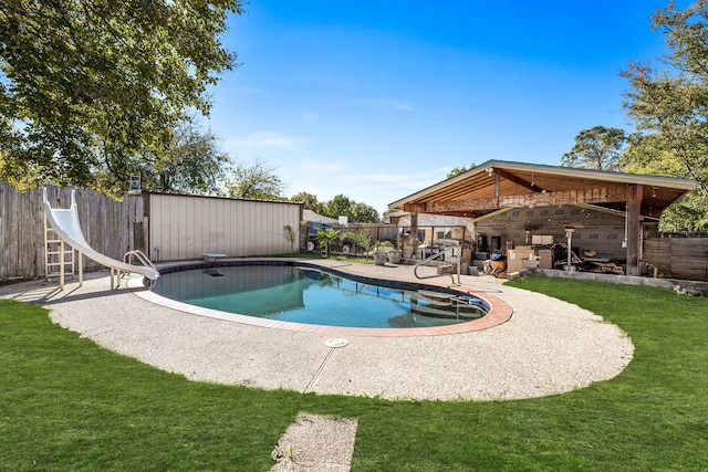 view of swimming pool with a patio, a lawn, and a water slide