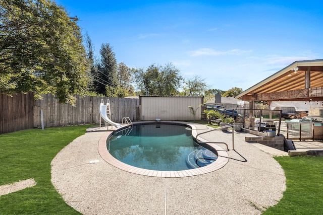 view of pool with a storage shed, a lawn, a patio, and a water slide