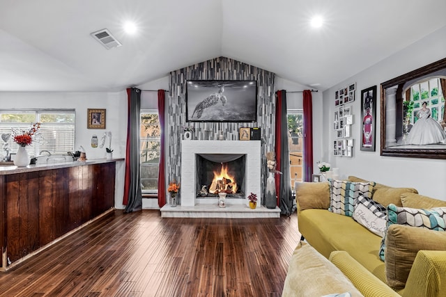 living room featuring a fireplace, hardwood / wood-style flooring, and vaulted ceiling