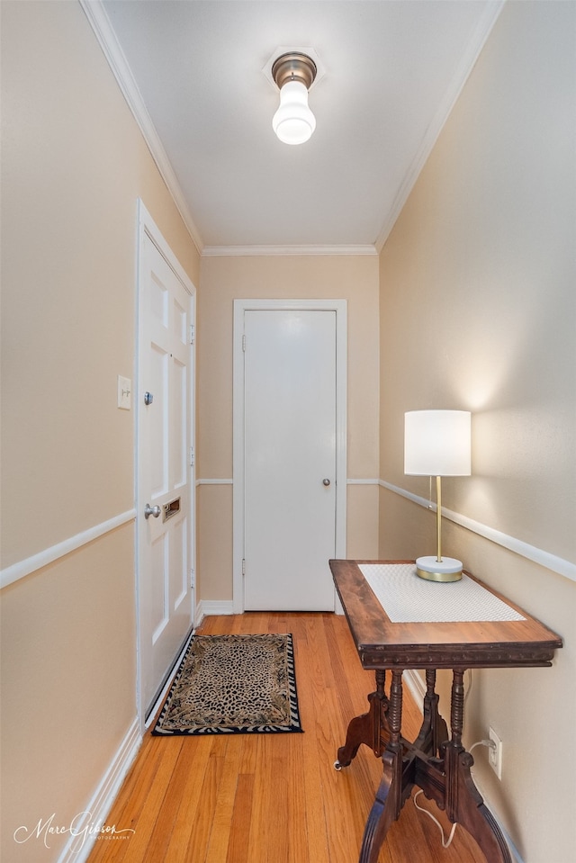 foyer entrance with crown molding and hardwood / wood-style flooring