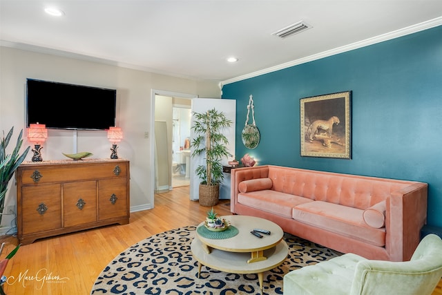 living room with light wood-type flooring and ornamental molding