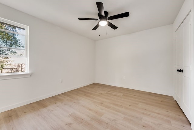 spare room with light hardwood / wood-style floors, a wealth of natural light, and ceiling fan