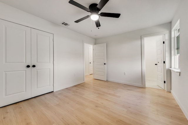 unfurnished bedroom with a closet, light hardwood / wood-style floors, and ceiling fan