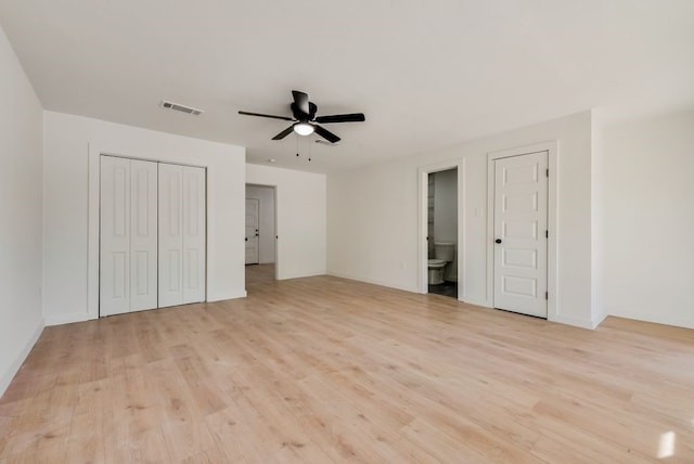 unfurnished bedroom featuring ceiling fan, ensuite bathroom, and light hardwood / wood-style floors