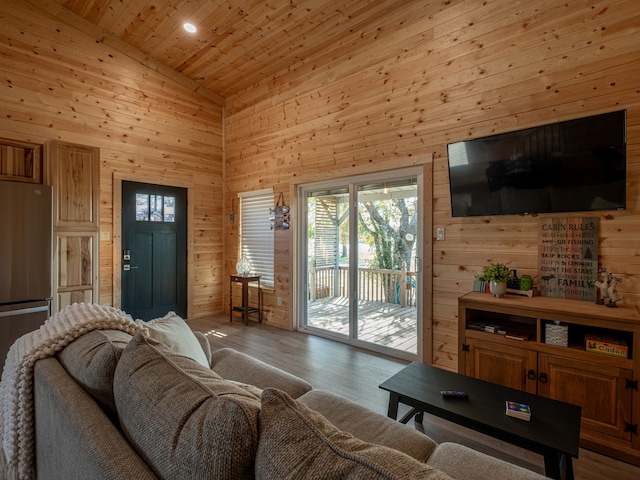 living room with wood-type flooring, wooden ceiling, high vaulted ceiling, and wooden walls