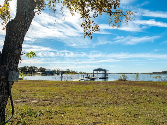 dock area with a yard, a water view, and boat lift