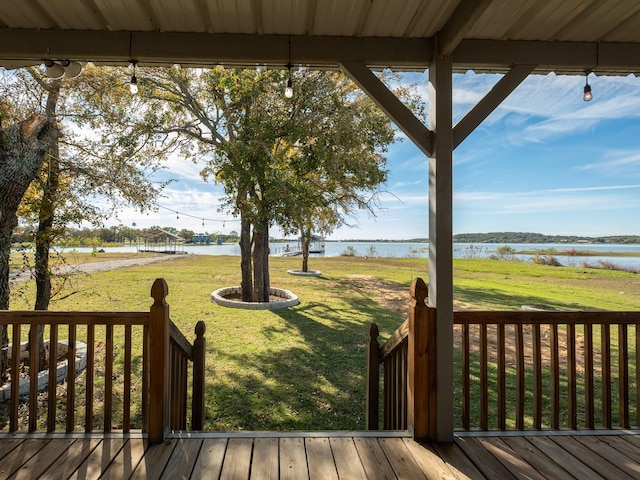 wooden terrace with a lawn and a water view