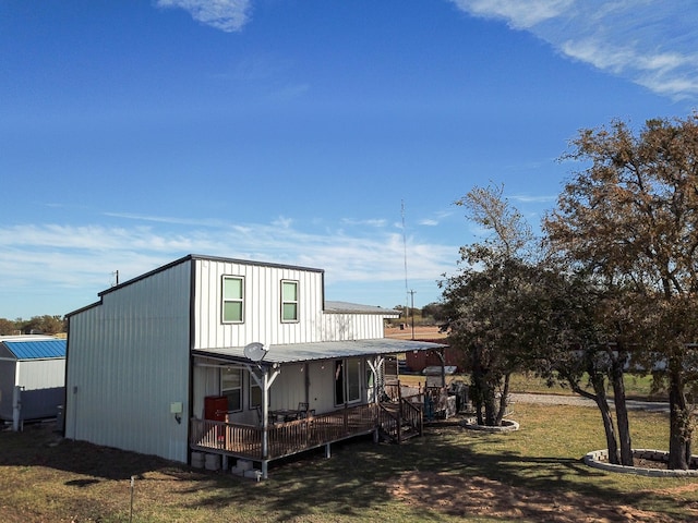 back of property with a deck and a yard