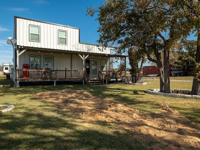 rear view of property featuring a yard, board and batten siding, and a wooden deck