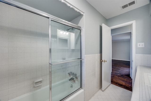 bathroom featuring shower / bath combination with glass door, tile walls, and hardwood / wood-style flooring