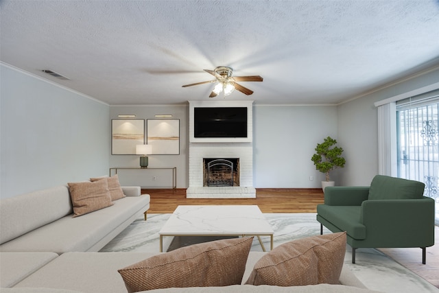 living room with a fireplace, light hardwood / wood-style floors, and ceiling fan