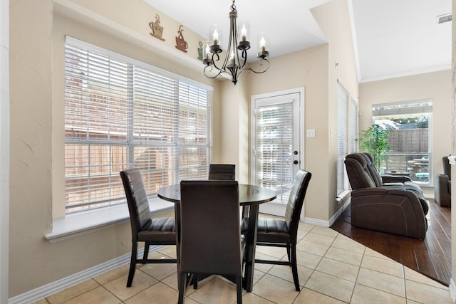 dining area featuring a notable chandelier, light tile patterned floors, and plenty of natural light