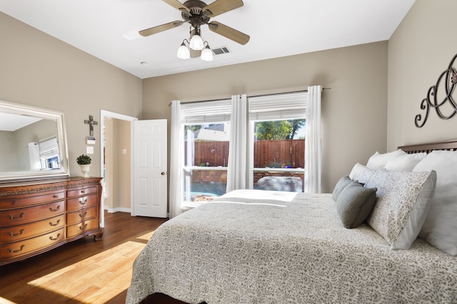 bedroom featuring ceiling fan, wood-type flooring, and multiple windows