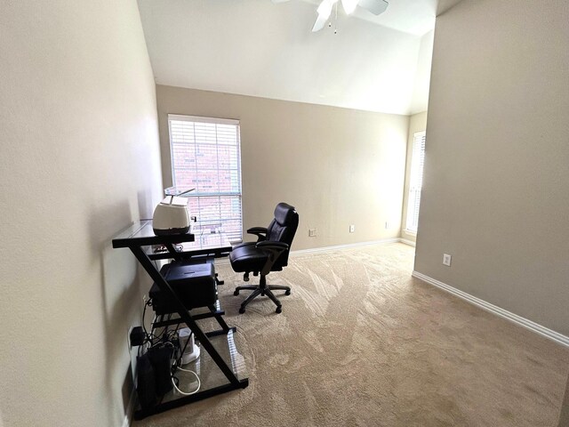 carpeted office space featuring lofted ceiling and ceiling fan