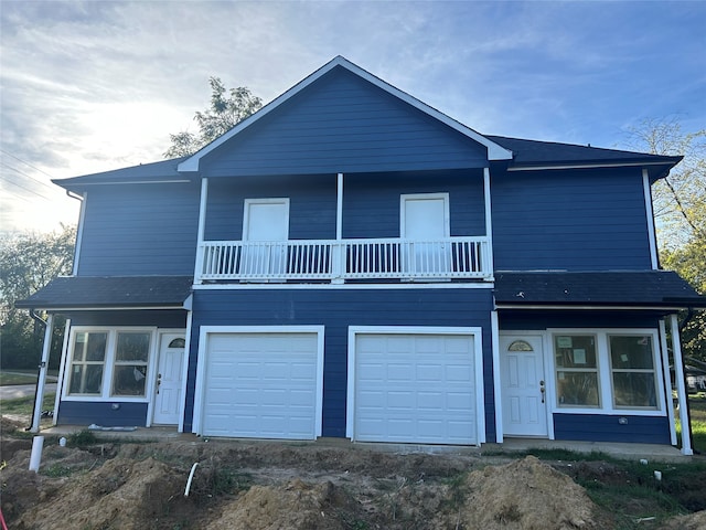 view of property with a garage and a balcony